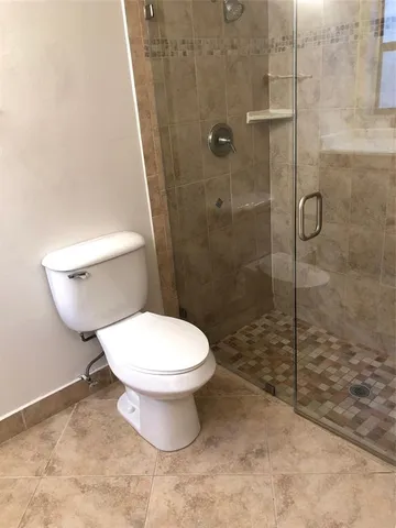 a bathroom with a toilet and a shower
