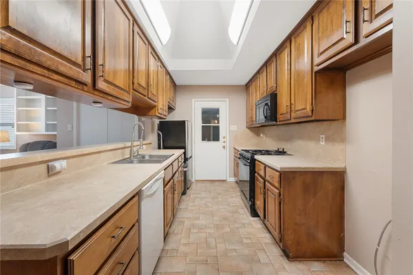 a kitchen with stainless steel appliances granite countertop a sink and a refrigerator