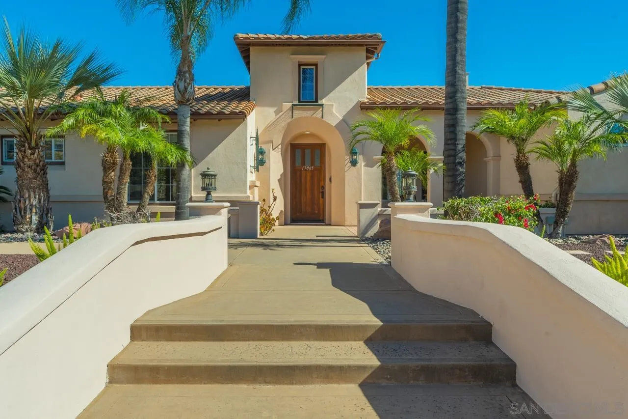 17065 Butterfield Trail Poway, CA 92064 - Photo 2 of 71 a view of a white house with swimming pool lawn chairs potted plants and palm tree