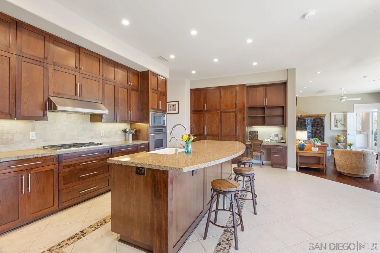 17065 Butterfield Trail Poway, CA 92064 - Photo 22 of 71 a kitchen with stainless steel appliances granite countertop a sink a stove a dining table and chairs