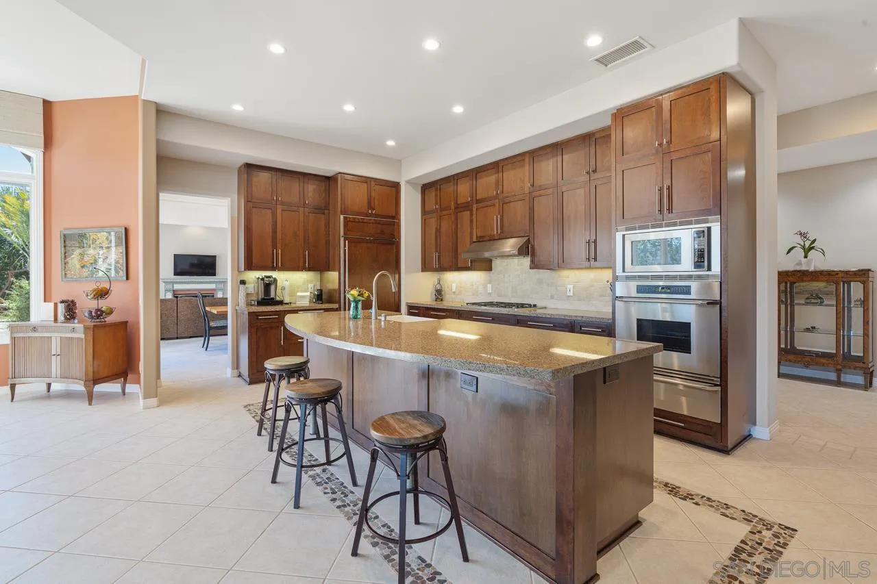 17065 Butterfield Trail Poway, CA 92064 - Photo 23 of 71 a kitchen with kitchen island granite countertop wooden cabinets a counter top space and stainless steel appliances