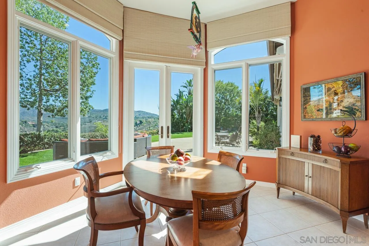 17065 Butterfield Trail Poway, CA 92064 - Photo 24 of 71 a view of a dining room with furniture large windows and wooden floor