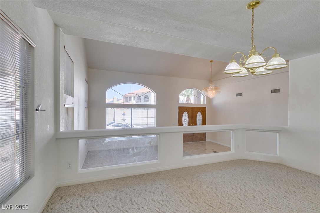 6 High Sierra Henderson, NV 89074 - Photo 15 of 56 Carpeted empty room with a chandelier, lofted ceiling, a textured ceiling, and baseboards