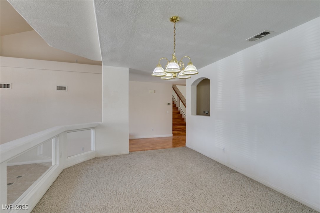 6 High Sierra Henderson, NV 89074 - Photo 16 of 56 Spare room with a chandelier, carpet flooring, and stairs
