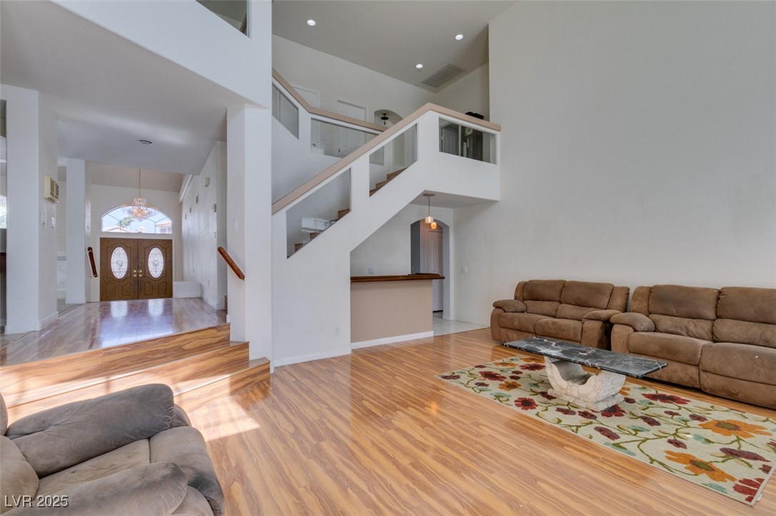 6 High Sierra Henderson, NV 89074 - Photo 21 of 56 Living area featuring stairway, a towering ceiling, wood finished floors, and recessed lighting