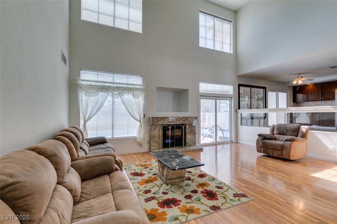 6 High Sierra Henderson, NV 89074 - Photo 23 of 56 Living room with a towering ceiling, wood finished floors, a premium fireplace, and ceiling fan