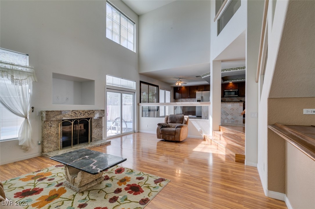 6 High Sierra Henderson, NV 89074 - Photo 24 of 56 Living area featuring a fireplace, wood finished floors, a high ceiling, and baseboards