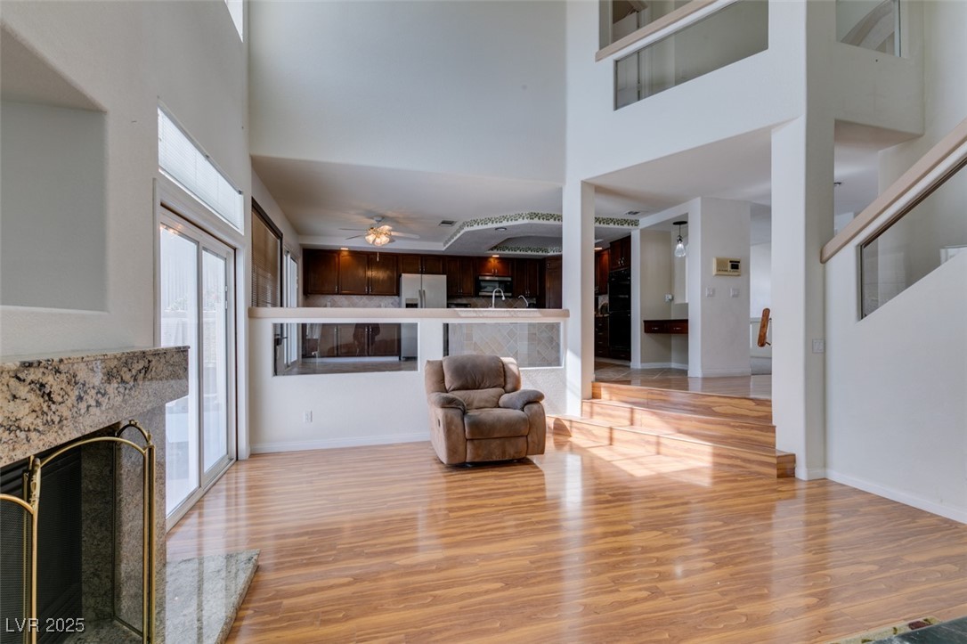 6 High Sierra Henderson, NV 89074 - Photo 25 of 56 Living area featuring plenty of natural light, a high ceiling, light wood-style flooring, a premium fireplace, and ceiling fan