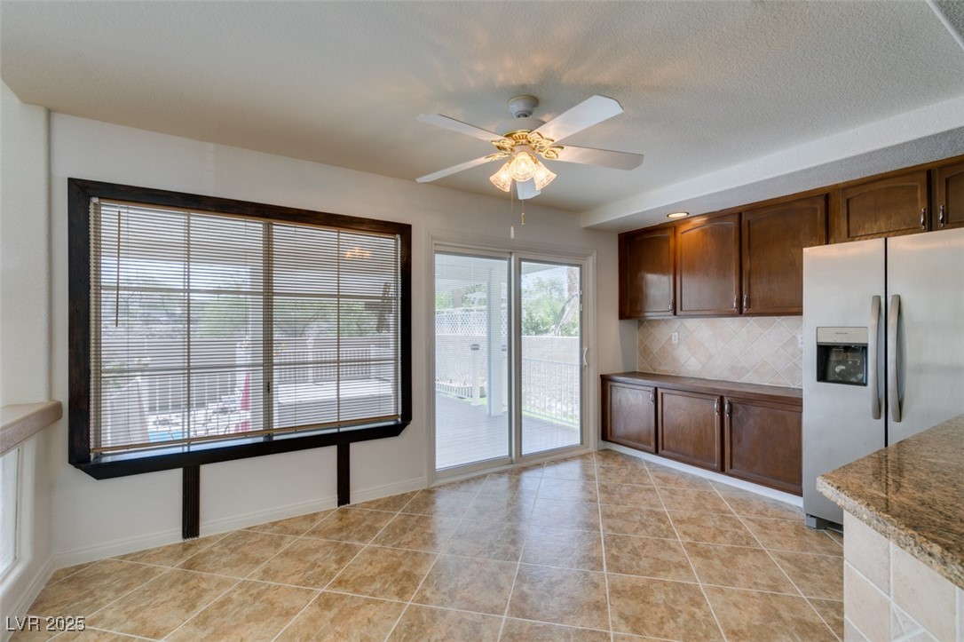 6 High Sierra Henderson, NV 89074 - Photo 28 of 56 Kitchen with stainless steel fridge, ceiling fan, decorative backsplash, light tile patterned flooring, and baseboards