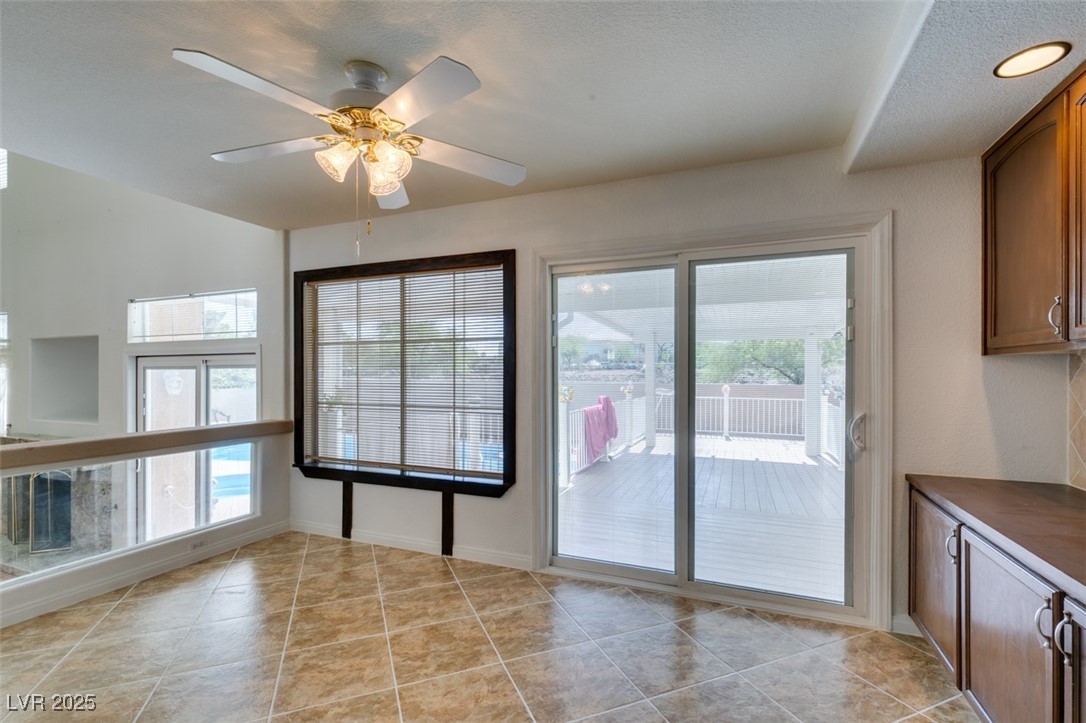6 High Sierra Henderson, NV 89074 - Photo 29 of 56 Unfurnished dining area with a ceiling fan, light tile patterned floors, and baseboards
