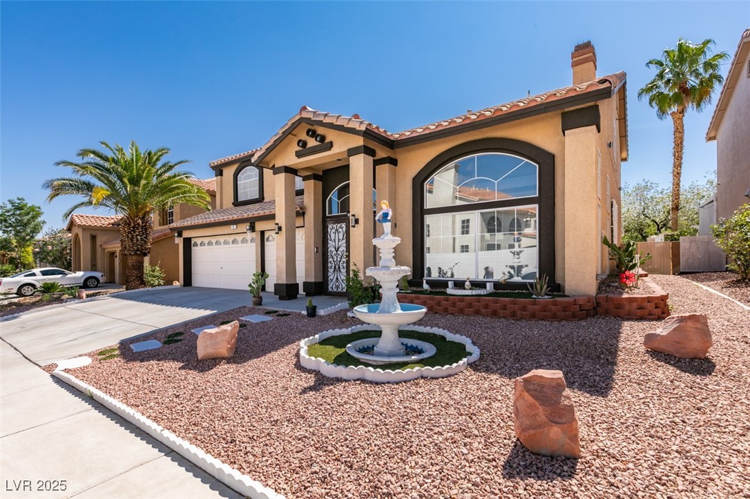 6 High Sierra Henderson, NV 89074 - Photo 3 of 56 Mediterranean / spanish home featuring stucco siding, driveway, a chimney, an attached garage, and a tiled roof