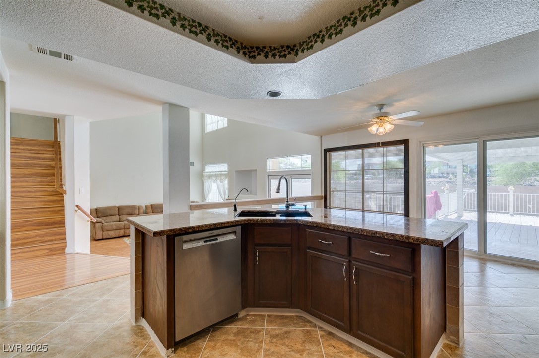 6 High Sierra Henderson, NV 89074 - Photo 56 of 56 Kitchen with stainless steel dishwasher, a sink, open floor plan, plenty of natural light, and a textured ceiling