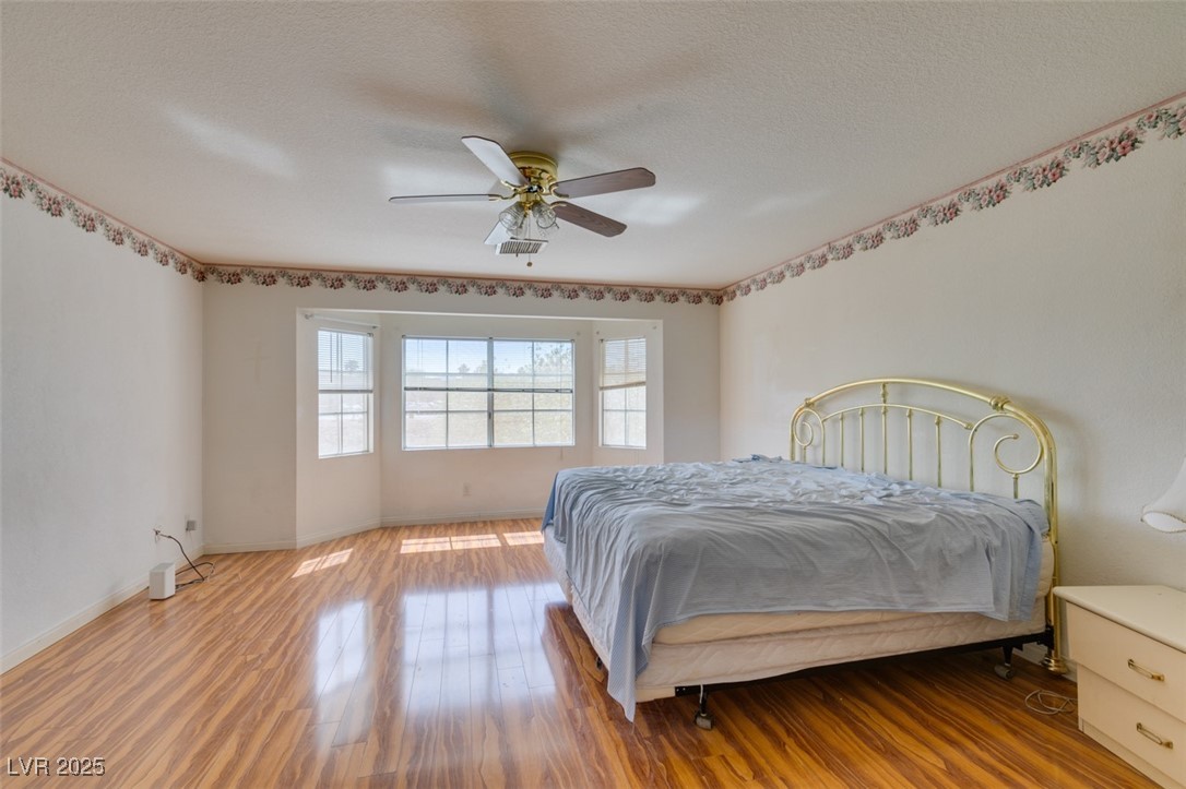 6 High Sierra Henderson, NV 89074 - Photo 43 of 56 Bedroom featuring wood finished floors, a ceiling fan, baseboards, and a textured ceiling