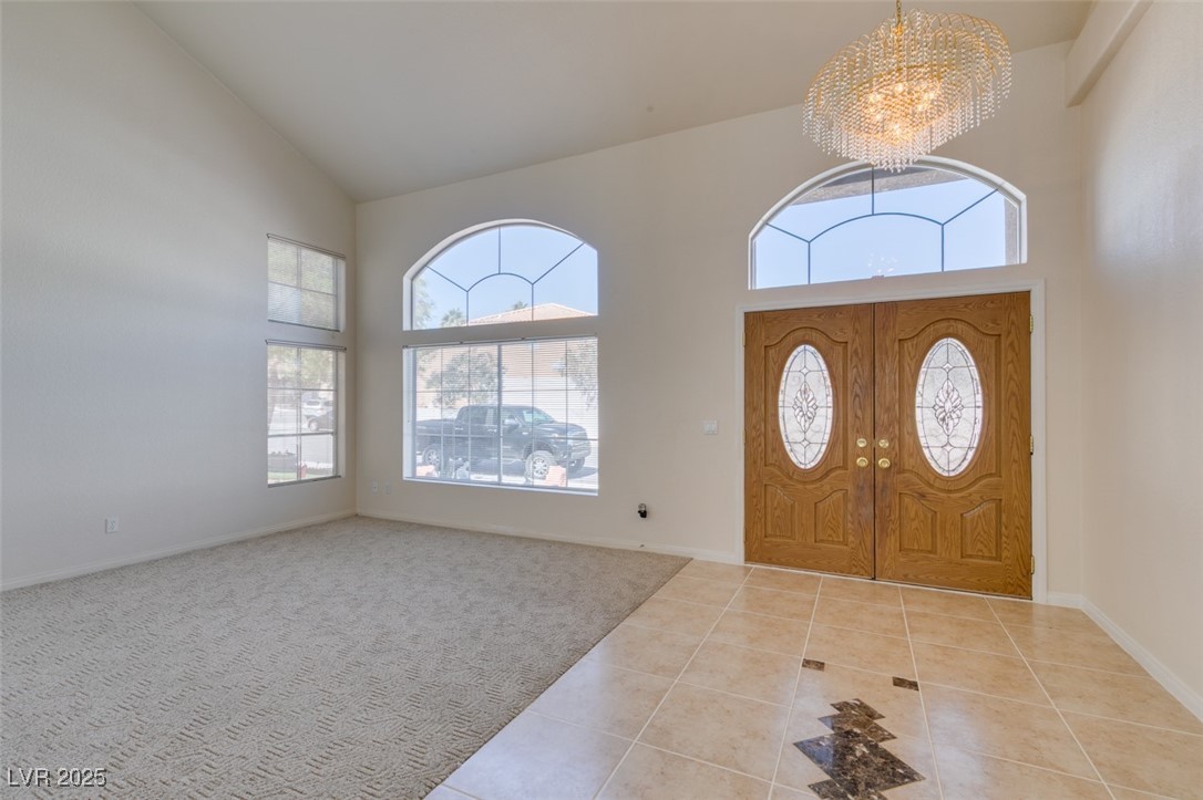 6 High Sierra Henderson, NV 89074 - Photo 7 of 56 Foyer entrance with a chandelier, high vaulted ceiling, healthy amount of natural light, tile patterned floors, and baseboards