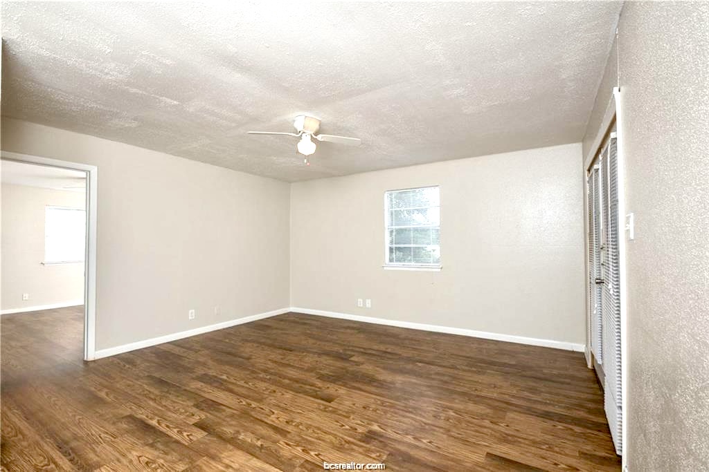 3900 Old College Road, Unit 33 Bryan, TX 77801 - Photo 8 of 11 a view of an empty room with wooden floor and a window
