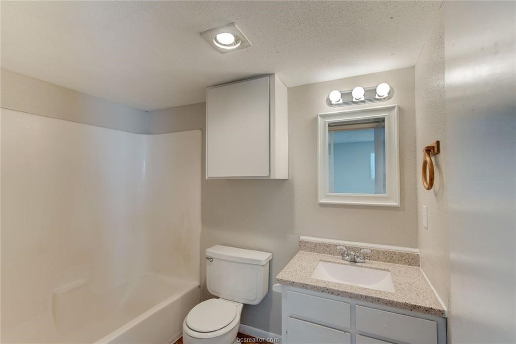 3900 Old College Road, Unit 33 Bryan, TX 77801 - Photo 8 of 10 a bathroom with a toilet sink and mirror