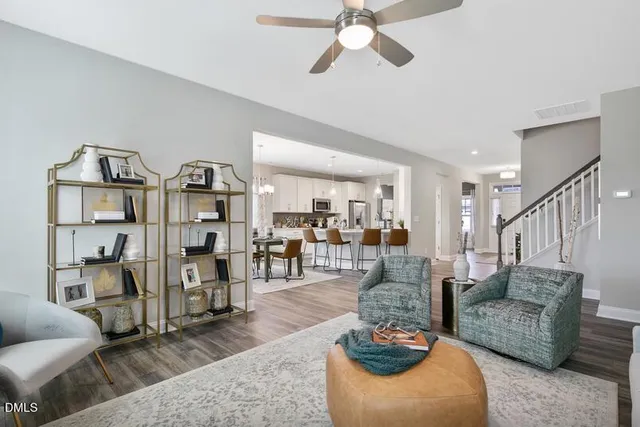 a living room with furniture kitchen view and a wooden floor