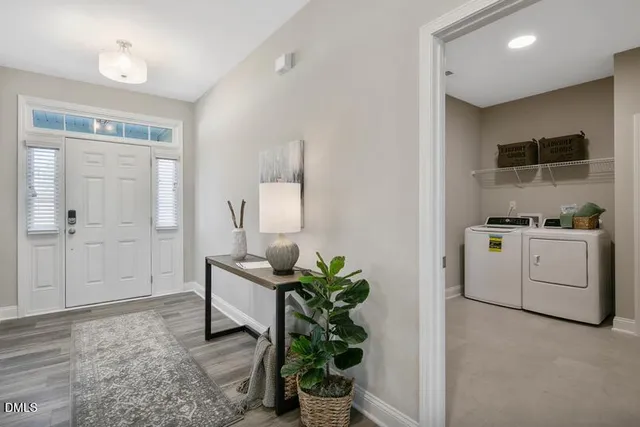 a hallway with white cabinets and wooden floor