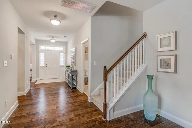 a view of a hallway with wooden floor and staircase