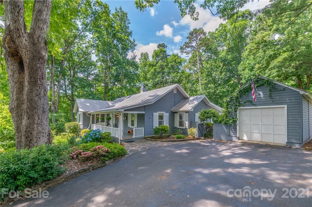 75 Hidden Hill Road Tryon, NC 28782 - Photo 2 of 36 a front view of a house with a garden