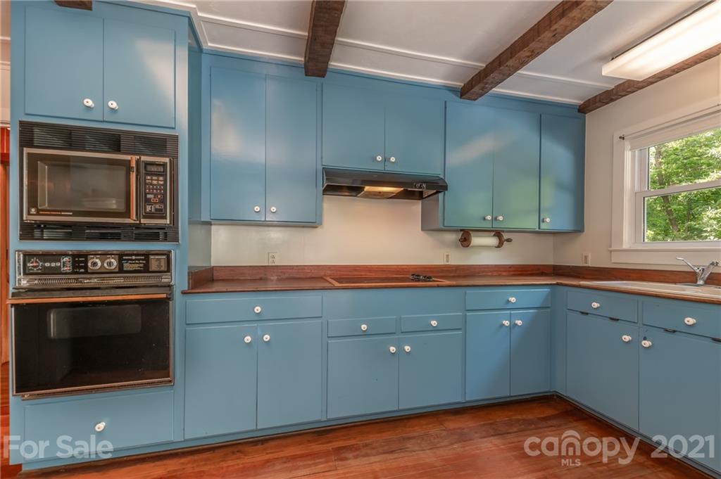 75 Hidden Hill Road Tryon, NC 28782 - Photo 24 of 36 a kitchen with stainless steel appliances granite countertop a stove a sink and a microwave