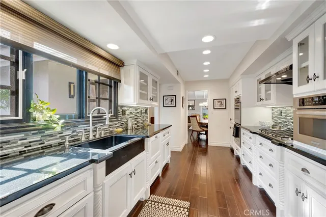 a large kitchen with lot of counter space and wooden floor