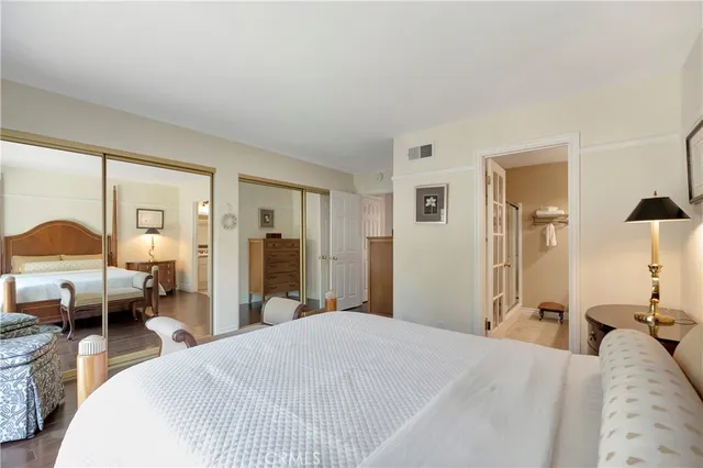 a bedroom with a bed and a large mirror