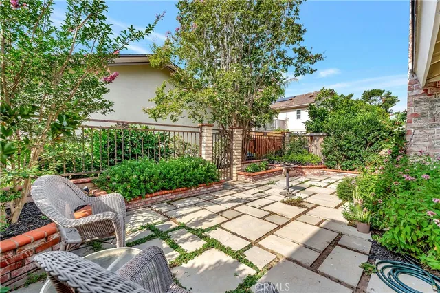 a patio with table and chairs and potted plants
