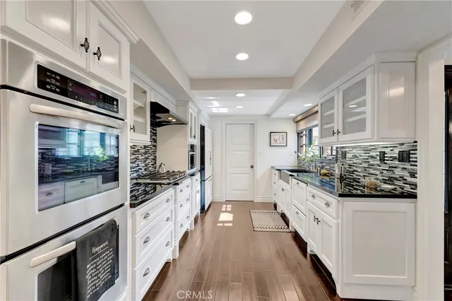 a large kitchen with stainless steel appliances kitchen island granite countertop a stove and a sink