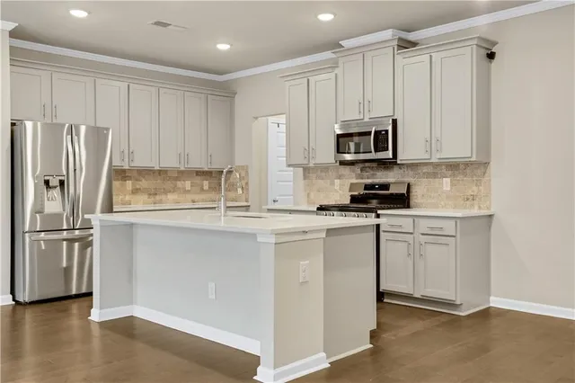a kitchen with stainless steel appliances granite countertop a refrigerator and a stove top oven