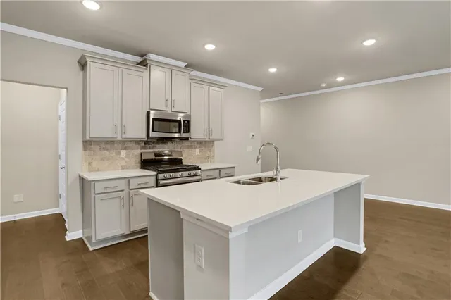a kitchen with a sink a stove a refrigerator and white cabinets