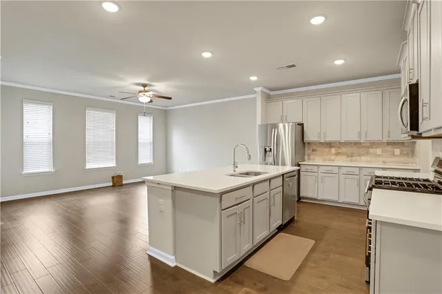 a kitchen that has a sink a stove and cabinets