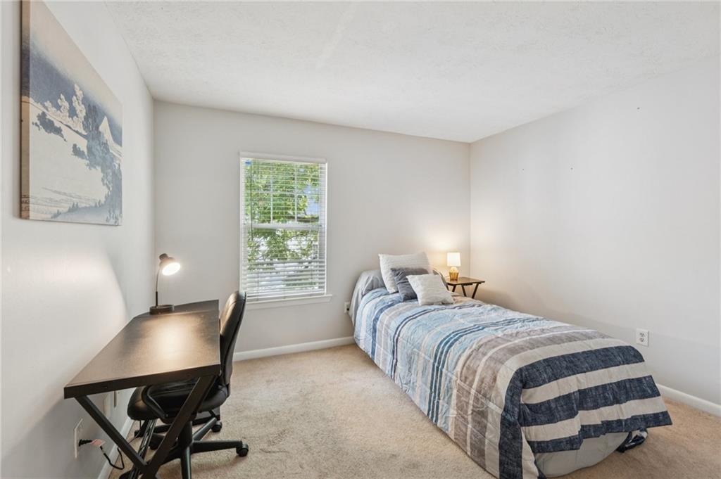 1150 Collier Road Northwest, Unit 16H Atlanta, GA 30318 - Photo 15 of 27 a bed room with a bed and a chair