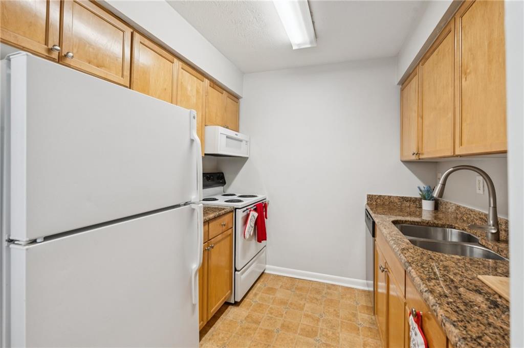 1150 Collier Road Northwest, Unit 16H Atlanta, GA 30318 - Photo 7 of 27 a view of storage and utility room with washer and dryer