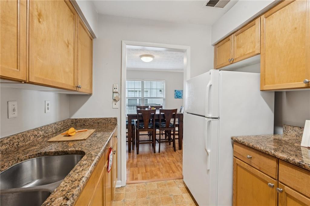 1150 Collier Road Northwest, Unit 16H Atlanta, GA 30318 - Photo 8 of 27 a kitchen with granite countertop a refrigerator and a sink