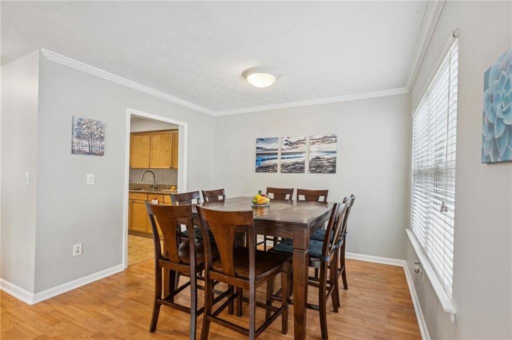 1150 Collier Road Northwest, Unit 16H Atlanta, GA 30318 - Photo 9 of 27 a view of a dining room with furniture and wooden floor