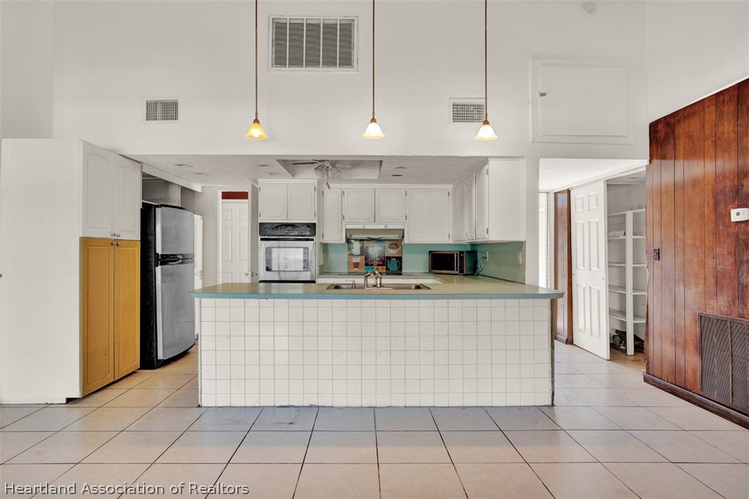 3204 Golfview Road Sebring, FL 33875 - Photo 11 of 36 a large kitchen with cabinets and stainless steel appliances