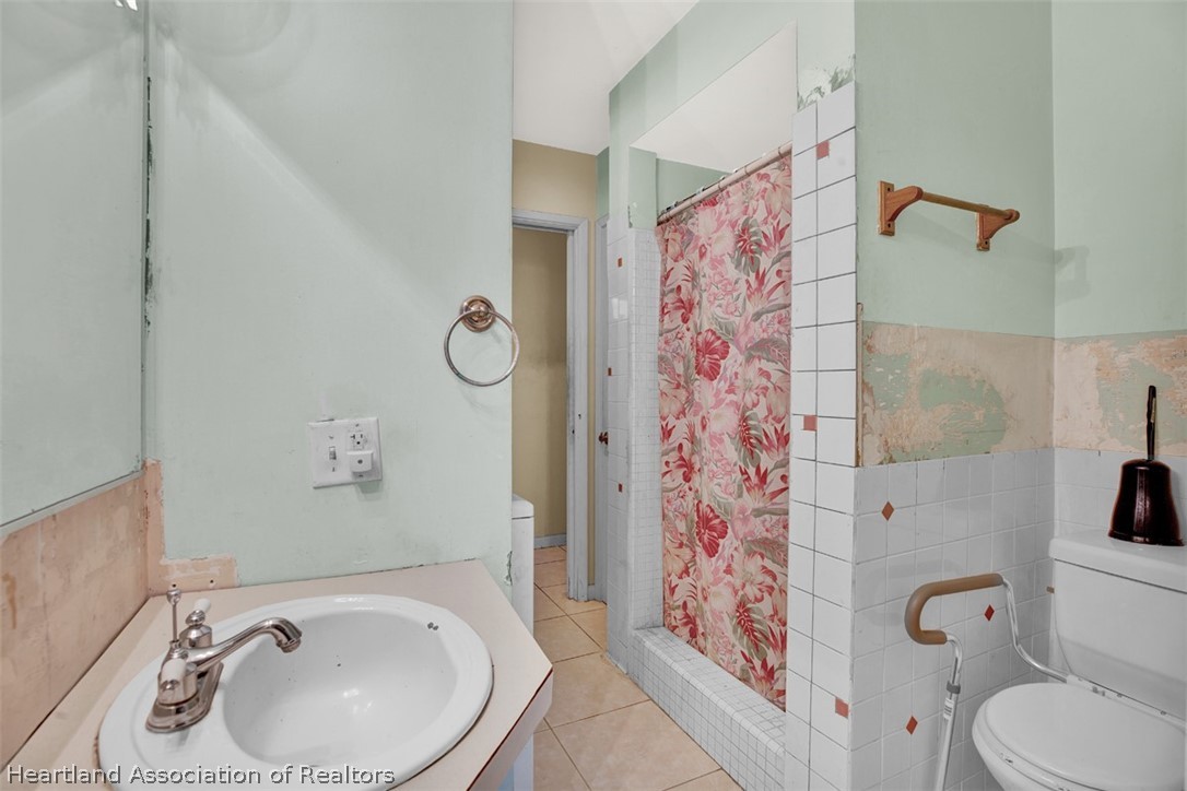 3204 Golfview Road Sebring, FL 33875 - Photo 13 of 36 a bathroom with a sink and mirror with toilet