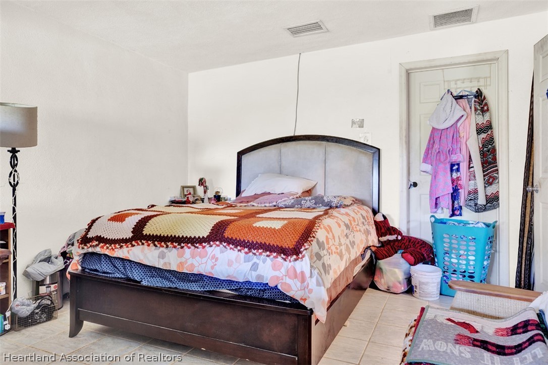 3204 Golfview Road Sebring, FL 33875 - Photo 25 of 36 a bedroom with a bed and a painting on the wall