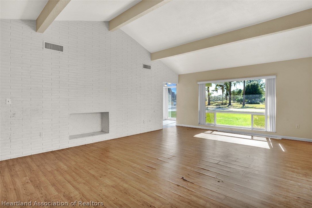 3204 Golfview Road Sebring, FL 33875 - Photo 8 of 36 a view of an empty room with a window and wooden floor