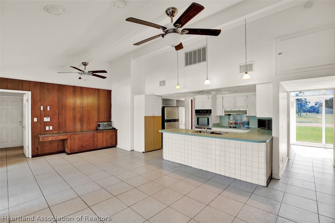 3204 Golfview Road Sebring, FL 33875 - Photo 9 of 36 a large white kitchen with a large window and refrigerator