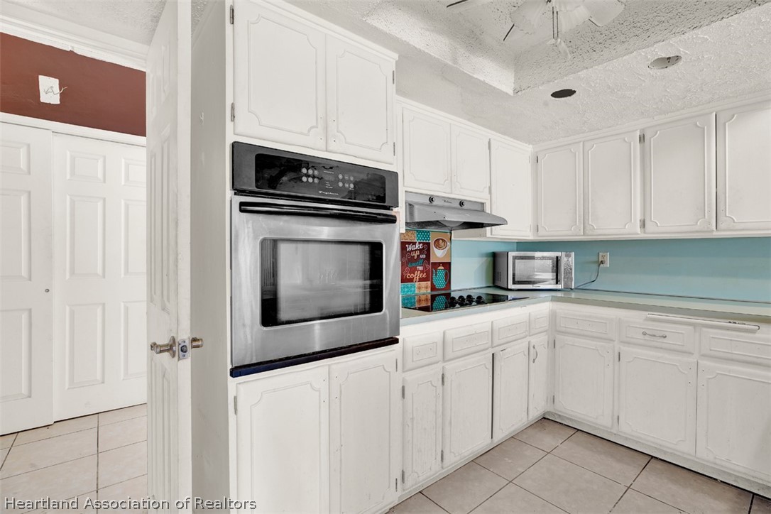 3204 Golfview Road Sebring, FL 33875 - Photo 10 of 36 a kitchen with white cabinets stainless steel appliances and sink
