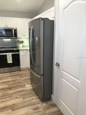 a kitchen with granite countertop a refrigerator and a stove top oven