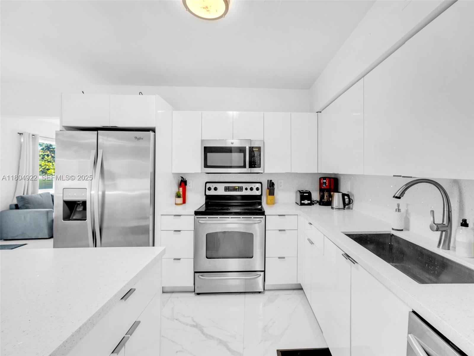 421 West Pembroke Road Hallandale Beach, FL 33009 - Photo 19 of 24 a kitchen with a sink a stove and refrigerator