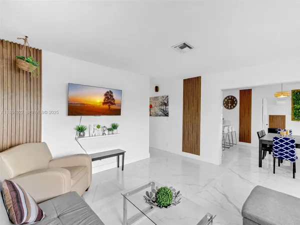 a living room with furniture a rug and a flat screen tv