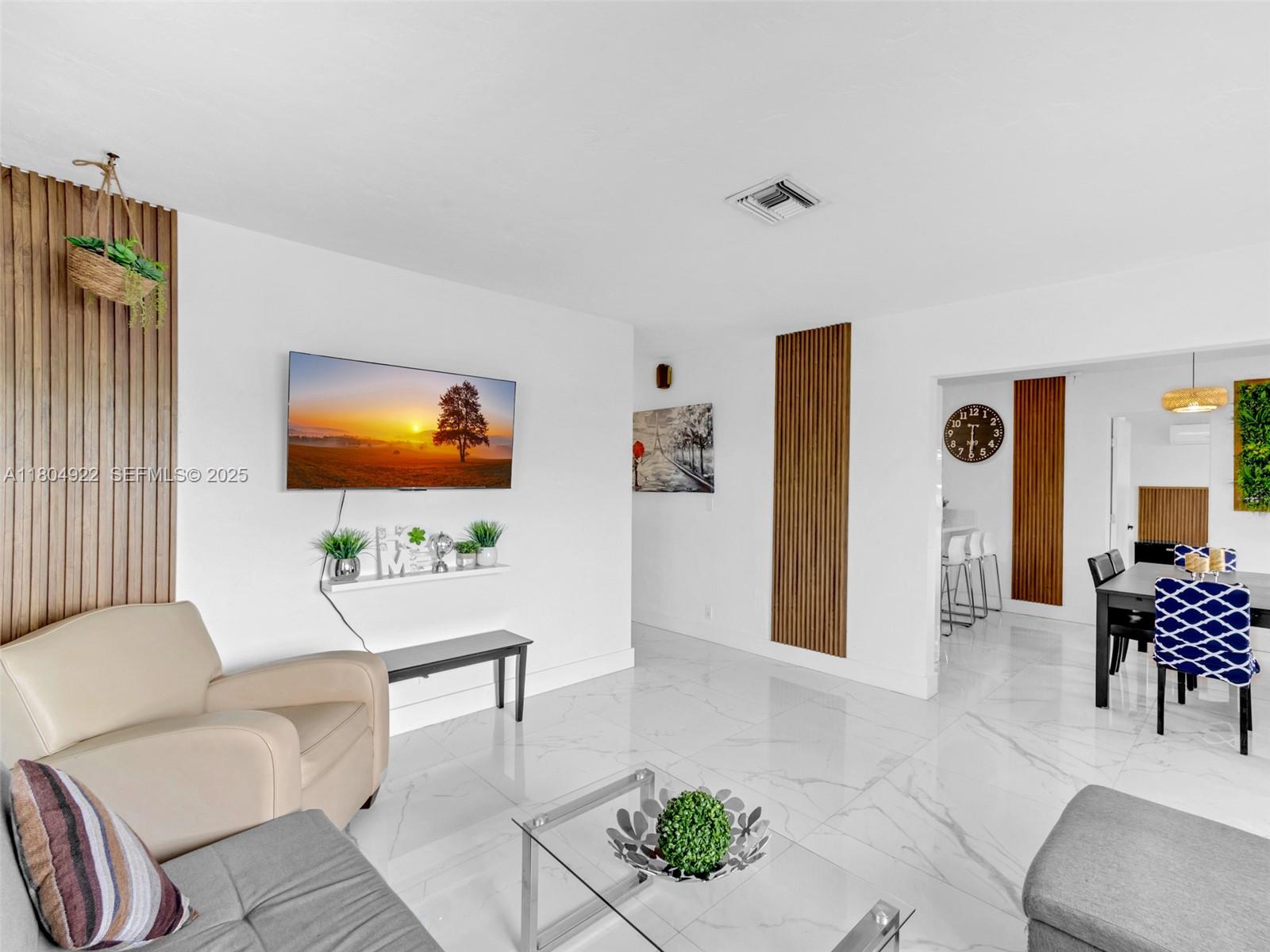 421 West Pembroke Road Hallandale Beach, FL 33009 - Photo 3 of 24 a living room with furniture a rug and a flat screen tv