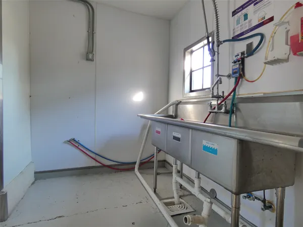 a room with gym equipment and wooden floor