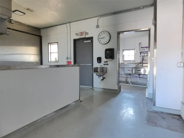 a view of a kitchen with fridge and wooden floor
