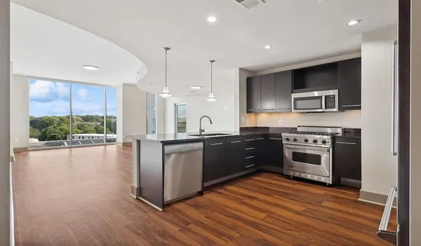 a large kitchen with stainless steel appliances granite countertop a stove a sink and a refrigerator
