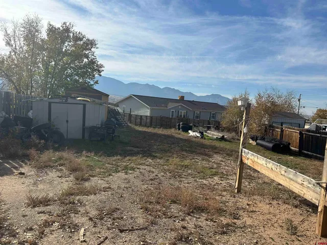 a view of a yard with wooden fence